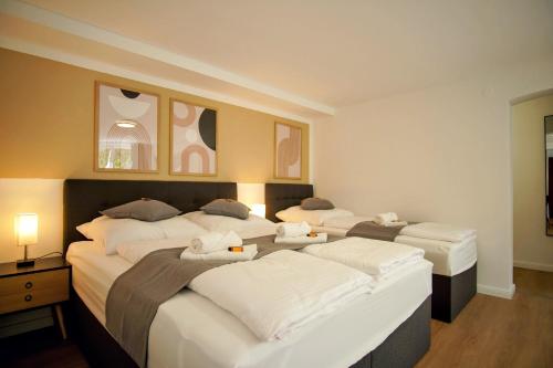 ein Hotelzimmer mit 3 Betten und weißer Bettwäsche in der Unterkunft ☆ANDRISS: Kaiserberg Apartments - Kitchen - WIFI - Parking in Kaiserslautern