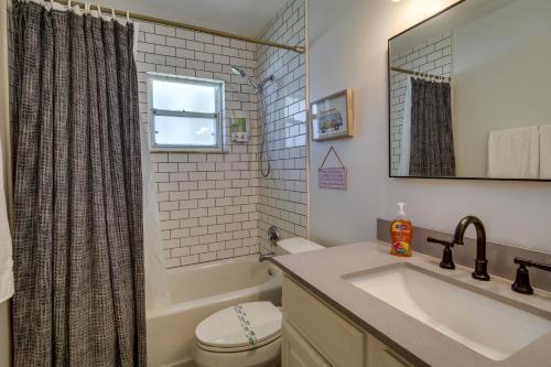 a bathroom with a sink and a toilet and a mirror at Dog-Friendly Vero Beach Retreat with Porch and Grill! in Vero Beach
