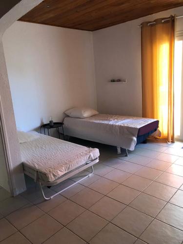 deux lits assis dans une pièce avec une fenêtre dans l'établissement Maison La Ribière, à Entrecasteaux