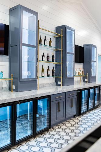 a bar with blue cabinets and shelves with bottles at Biddle Point Inn in Plymouth