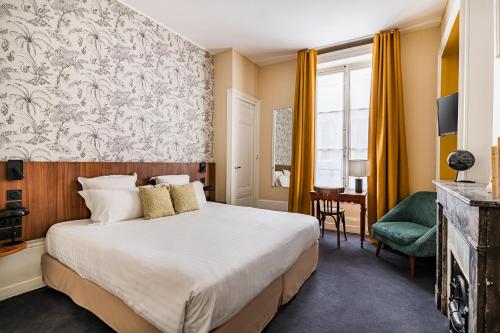ein Hotelzimmer mit einem großen Bett und einem Schreibtisch in der Unterkunft Globe Et Cecil in Lyon