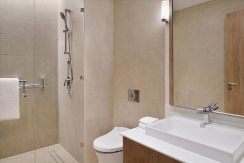 a bathroom with a toilet and a sink and a shower at Element by Westin City Center Doha in Doha