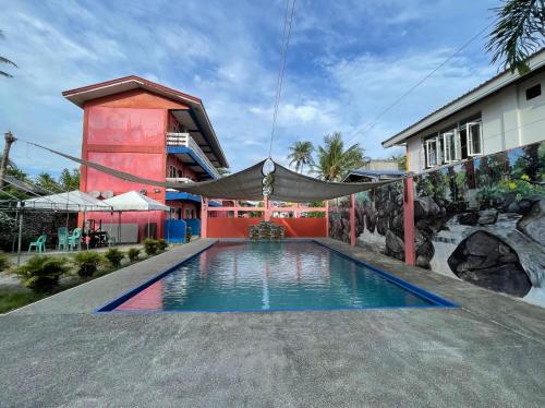 a swimming pool in front of a house at Jamjens Lodge powered by Cocotel in Baler