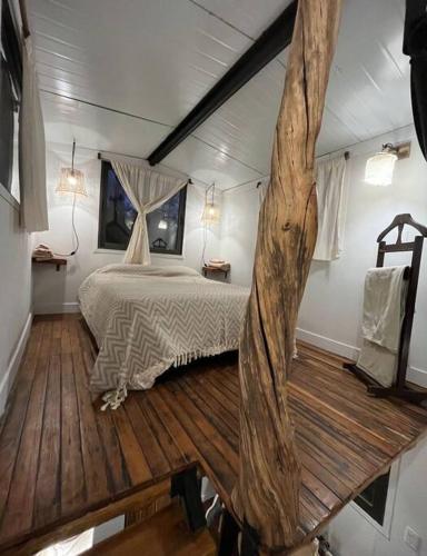 un dormitorio con una cama y un árbol dentro en Tiny House - Chacras de Coria by Inside en Luján de Cuyo