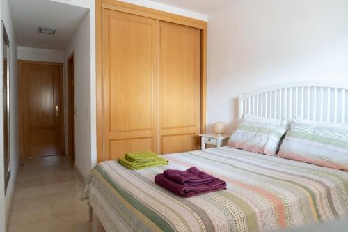 een slaapkamer met een bed met twee handdoeken erop bij Gran terraza, al lado del mar. in Fuengirola