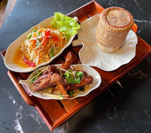dois pratos de comida num tabuleiro de madeira em Pen's Bungalow Koh Phangan em Thong Nai Pan Yai