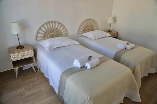 two beds in a hotel room with towels on them at Sítio DaTerra in Santo António da Terrugem