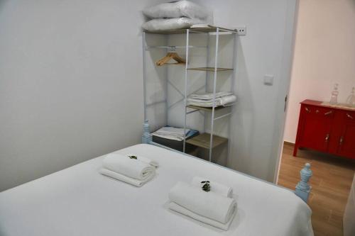 uma cama branca com duas toalhas em cima em Sítio DaTerra em Santo António da Terrugem