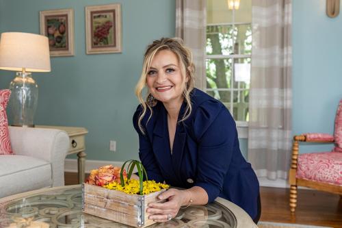 a woman sitting at a table with a basket of flowers at Biddle Point Inn in Plymouth