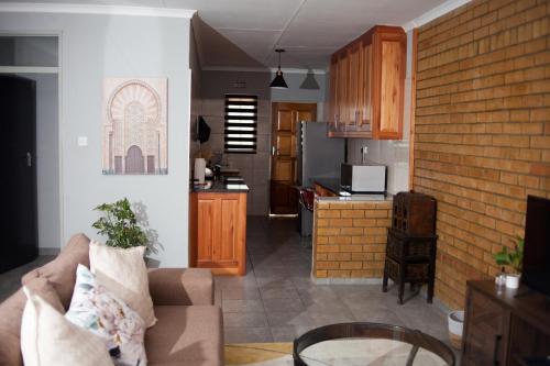 a living room with a couch and a kitchen at The Cosy Crib in Palatswe