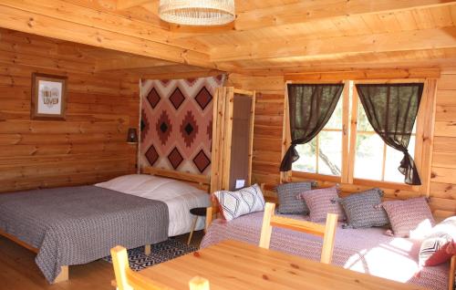a bedroom with two beds in a log cabin at Quinta D' LuzArcoIris in Arganil