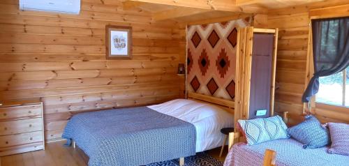 a bedroom with a bed in a log cabin at Quinta D' LuzArcoIris in Arganil