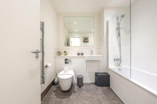 a bathroom with a toilet and a tub and a sink at Modern 1 Bedroom Apartment in the center of Bedford in Bedford