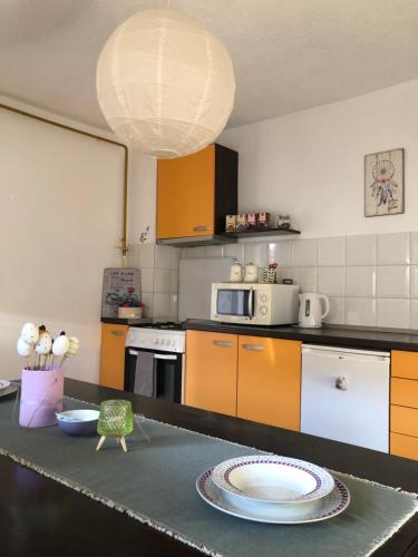 een keuken met oranje en witte kasten en een bord op een aanrecht bij Apartment Incognito in Sarajevo