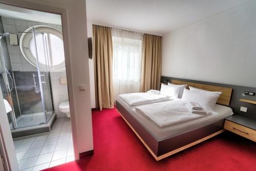 1 dormitorio con 1 cama y baño con ducha en Hotel Tanne, en Saalfeld