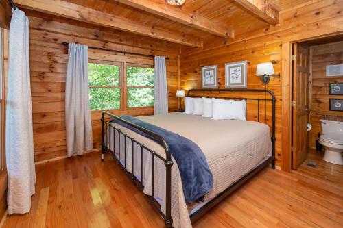 - une chambre avec un lit dans une cabane en rondins dans l'établissement Snowshoe Lodge, à Sevierville