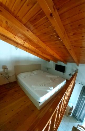a bed in a room with a wooden ceiling at Apartments Barbie in Rethymno Town
