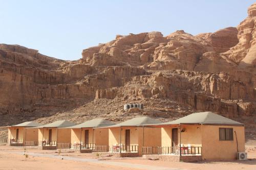 a building in the desert next to a mountain at Hakuna matata desert camp in Wadi Rum