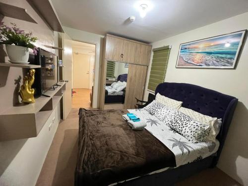um quarto com uma cama com uma cabeceira azul em Jay's Condo - Seawind em Davao