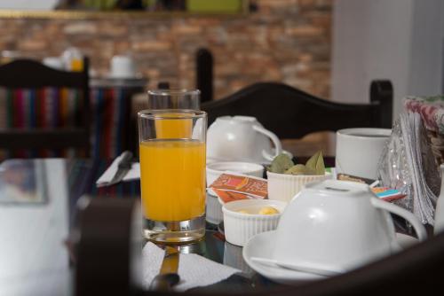 a glass of orange juice sitting on a table at Ayenda Casa Aika Sucre in Lima