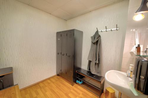 a bathroom with a sink and a door in the wall at Hotel Tanne in Saalfeld