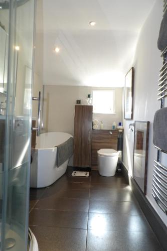 a bathroom with a tub and a toilet and a sink at Aigas in Glasgow