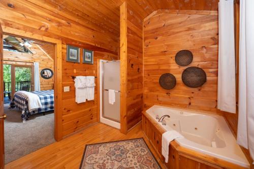 d'une salle de bains en rondins avec baignoire et d'une chambre. dans l'établissement Snowshoe Lodge, à Sevierville
