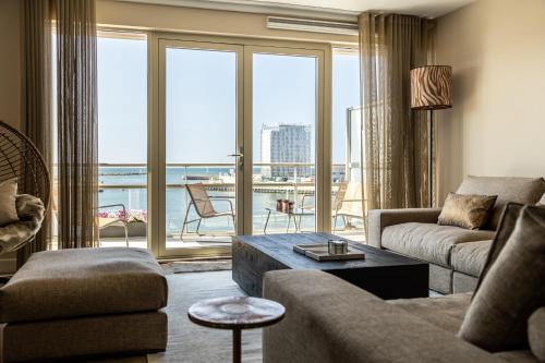 斯海弗寧恩的住宿－BizStay Harbour III Scheveningen Apartments，带沙发和大窗户的客厅