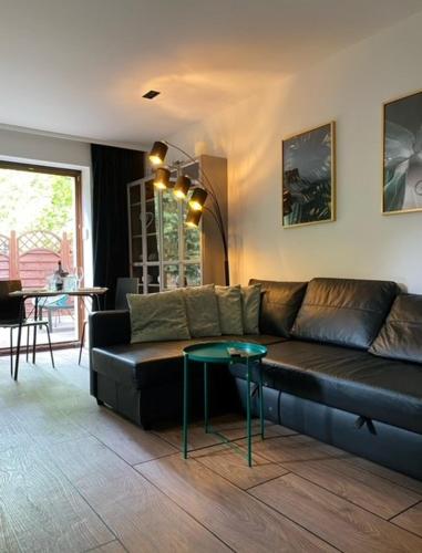 a living room with a black couch and a table at MYSTAY BERLIN Müggelheim in Berlin