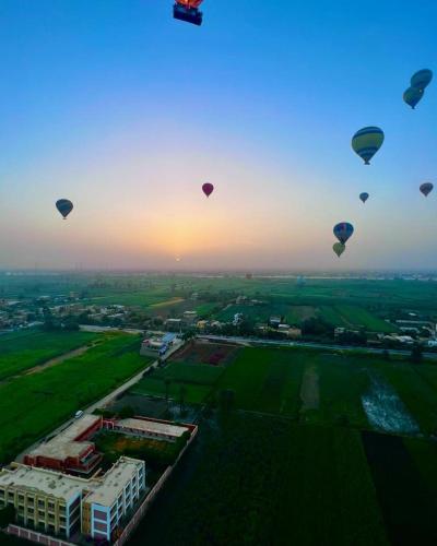 a group of hot air balloons flying in the sky at West view in Khuzām
