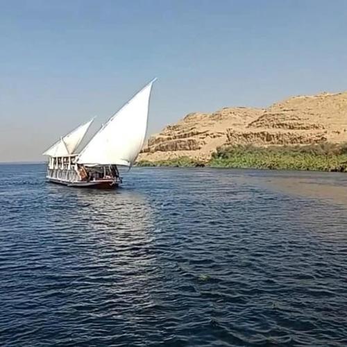 een boot met een groot wit zeil op het water bij West view in Khuzām