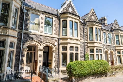 a large brick house with a hedge in front of it at Charming Elegance at The Pontcanna Pearl - Prime Location with Comfort and Style in Cardiff