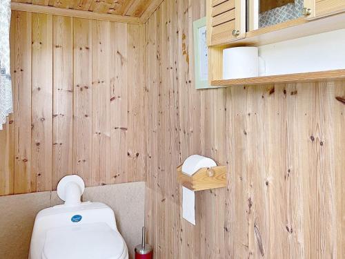 uma casa de banho com um WC e uma parede de madeira em Holiday home RIMBO III em Rimbo