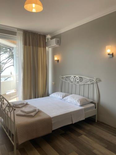1 dormitorio con cama con marco de metal y ventana en Argo Hotel, en Ureki