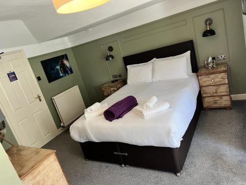 a bedroom with a large bed with towels on it at The Plough Inn in Marsham