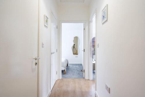 um corredor com paredes brancas e um quarto com uma cama em Newport Ship's Nook: Cozy Hideaway em Newport
