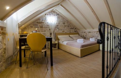 a bedroom with a bed and a desk in a attic at Apartments Kaja in Trogir