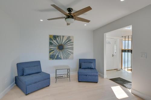 two blue chairs and a ceiling fan in a living room at Spacious Rocky Point Retreat with Al Fresco Dining! in Rocky Point