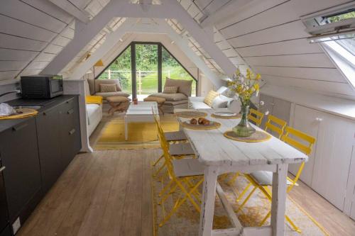 - une cuisine et un salon avec une table dans une petite maison dans l'établissement Maison à Saint Briac chez Delphine, à Saint-Briac-sur-Mer