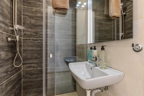 y baño con lavabo y ducha. en Golden Sunsets Penthouse 10 by Solea, en San Ġwann