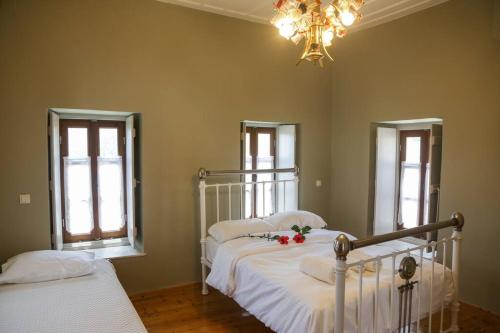 Un dormitorio con dos camas y una lámpara de araña. en Stylianos House 3, en Leonidio
