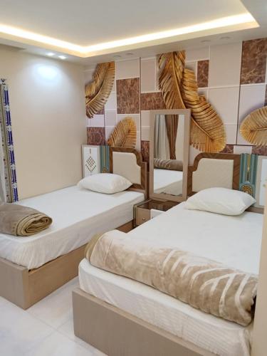 Zimmer mit 3 Betten und einem Spiegel in der Unterkunft super lux furnished apartment in Al Muhandeseen with a view on the Nile in Kairo