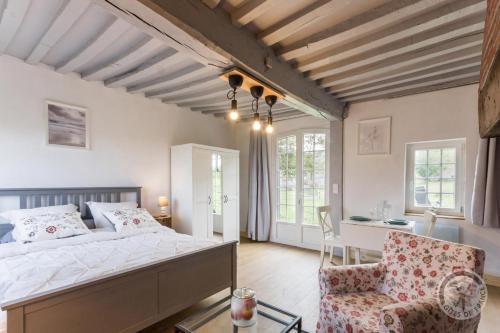 1 dormitorio con 1 cama, 1 silla y 1 mesa en La Maisonnette en Saint-Pierre-sur-Dives