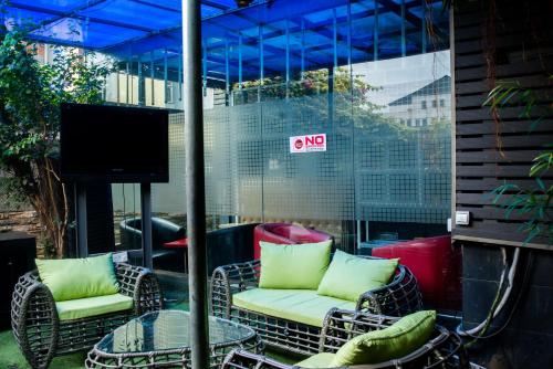 a patio with chairs and a table and a tv at Sese Cottage in Ikeja