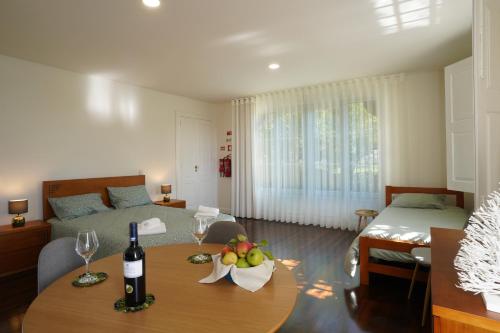 a living room with a bed and a table with wine glasses at Casa da Costeira in Guimarães