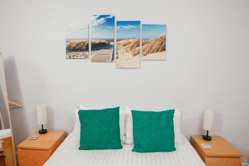 a bedroom with a bed with green pillows at Peaceful Oasis By The Sea in Edinburgh