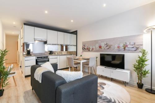 uma sala de estar com um sofá, uma mesa e uma cozinha em Zenitude - Casa Vostra - Thonon Centre et Thermes em Thonon-les-Bains