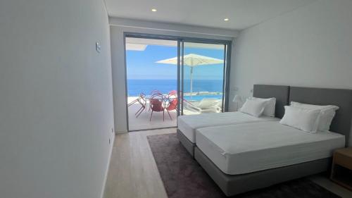 a bedroom with a bed and a view of the ocean at Villa Camacho V - Luxurious Villa in Estreito da Calheta
