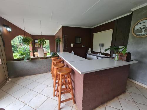 a kitchen with a counter and some stools in a room at Riverrun Resort Farmhouse in Tygerfontein