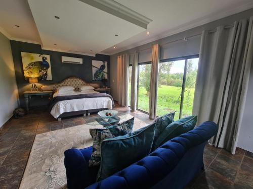 a bedroom with a bed and a couch and a table at Riverrun Resort Farmhouse in Tygerfontein